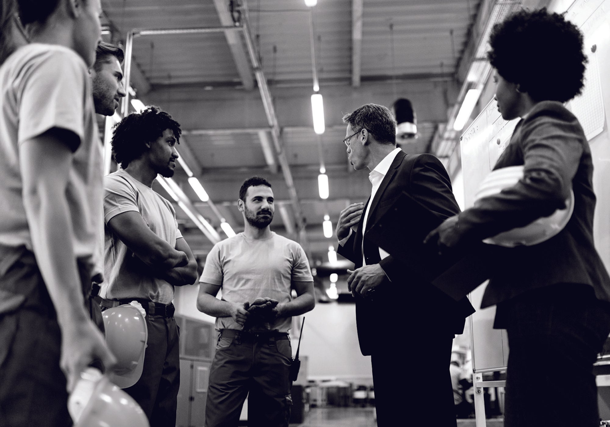 a manager speaking to his team in a factory